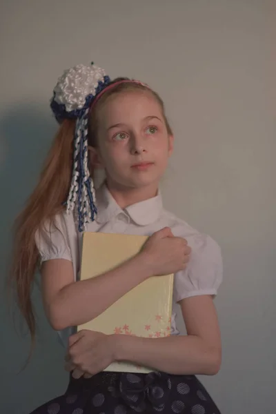 Fata scolarita sta pe un perete alb — Fotografie, imagine de stoc