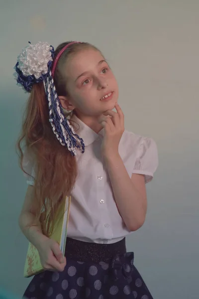 Flicka Schoolgirl står mot en vit vägg — Stockfoto