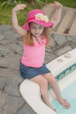 Havuz kenarında dinlenen çocuk kız.