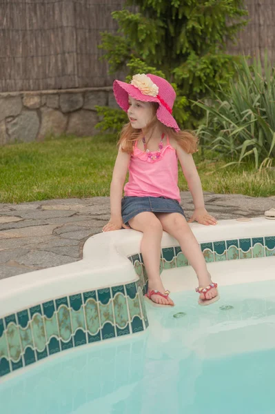 Παιδί κορίτσι αναπαύεται κοντά στην πισίνα. — Φωτογραφία Αρχείου