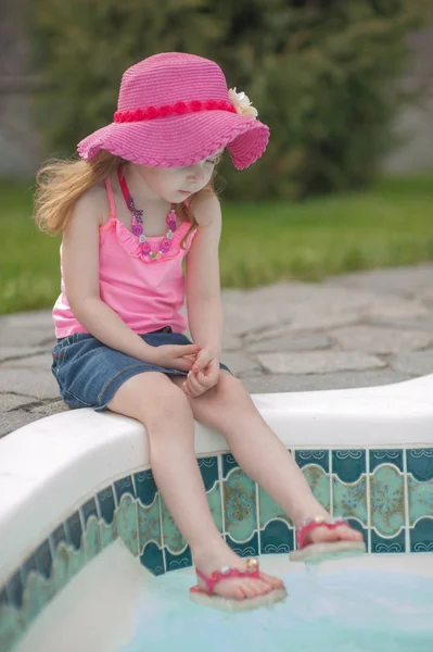 O fetiță se odihnește lângă piscină . — Fotografie, imagine de stoc