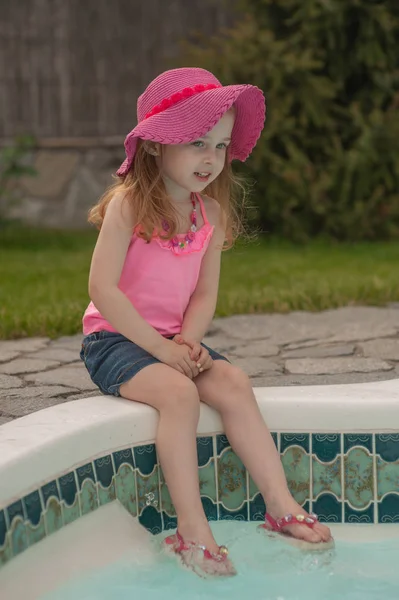 O fetiță se odihnește lângă piscină . — Fotografie, imagine de stoc