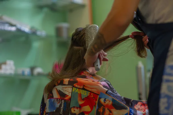 Stilist kuaför bir güzellik salonunda sevimli bir küçük kız için bir saç modeli yapar. Kuaförlük, saç kesimi. — Stok fotoğraf