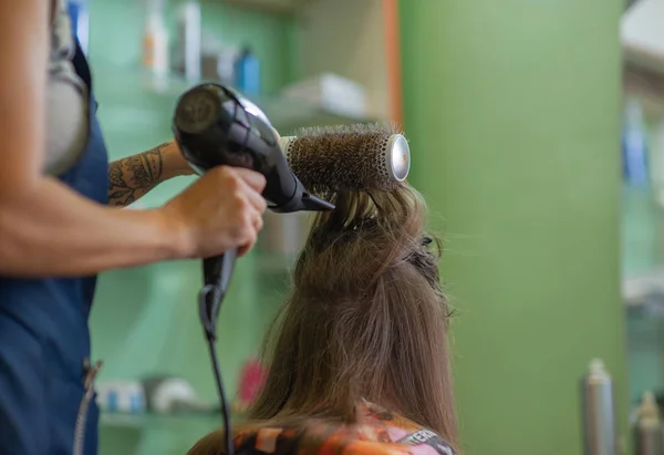 Stylist hairdresser makes a hairstyle for a cute little girl in a beauty salon. Hairdressing, hair cutting. — Stock Photo, Image