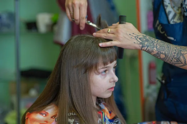 スタイリストの美容師は、美容院でかわいい女の子のためのヘアスタイルを作ります。美容、ヘアカット. — ストック写真