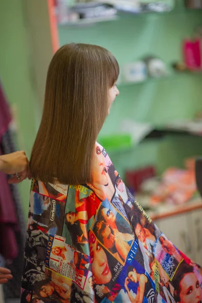 Stylist Frisör gör en frisyr för en söt liten flicka i en skönhetssalong. Hårdressing, hårklippning. — Stockfoto