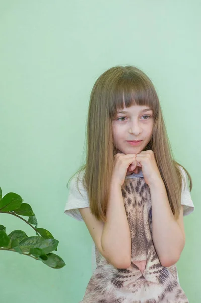 Menina 9 anos em um fundo verde. Cabeleireiro, corte de cabelo . — Fotografia de Stock