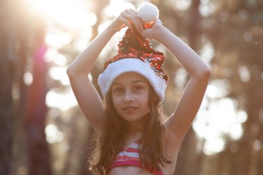 Bir çocuk Noel Baba şapkasıyla oynuyor. Yaz aylarında Noel Baba şapka lı mutlu küçük kız .