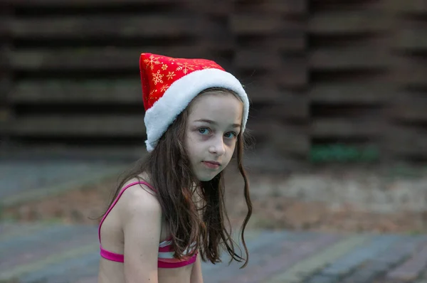 Kleines Mädchen mit Weihnachtsmann-Hut am Pool — Stockfoto
