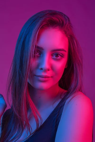 Neon ışığı kırmızı ve mavi güzel brunete kadında closeup yüzü. — Stok fotoğraf