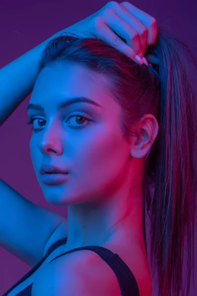 Neon ışığı kırmızı ve mavi güzel brunete kadında closeup yüzü. — Stok fotoğraf