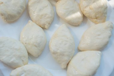 Kızartmak için pasta. Çeşitli dolgular ile oluşan turta beyaz bir tabak üzerinde yalan ve yağda kızartılmış hazır