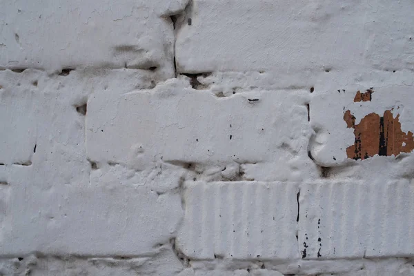 Brick white wall.Red brick is painted white with whitewash. Corner of a clouded wall. The old wall.