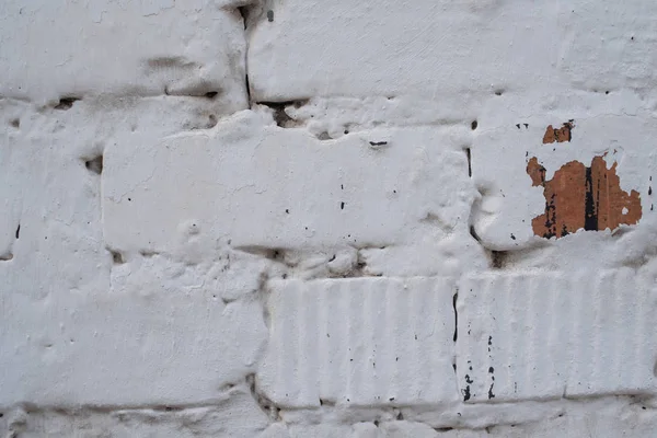 Brick white wall.Red brick is painted white with whitewash. Corner of a clouded wall. The old wall.