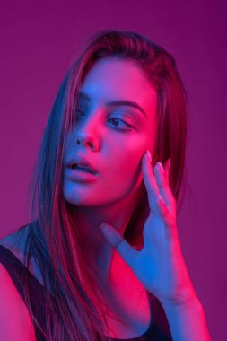 Tombul doğal dudakları ile Muhteşem esmer. Model renk filtreleri ile stüdyoda uzun pozlama vurdu. Moda, güzellik, parıltı. Neon açık kırmızı ve mavi güzel brunete kadının Closeup yüzü.