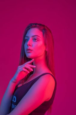 Tombul doğal dudakları ile Muhteşem esmer. Model renk filtreleri ile stüdyoda uzun pozlama vurdu. Moda, güzellik, parıltı. Neon açık kırmızı ve mavi güzel brunete kadının Closeup yüzü.