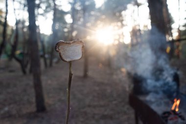 Ahşap şişler üzerinde yumuşar, ahşap alevler üzerinde kızarır.