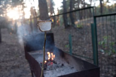 Ahşap şişler üzerinde yumuşar, ahşap alevler üzerinde kızarır.