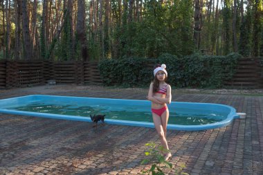 Bir çocuk Noel Baba şapkasıyla oynuyor. Yaz aylarında Noel Baba şapka lı mutlu küçük kız.