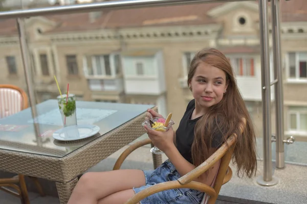 아름다운 젊은 여성 이 행복하게 웃으면서, 식당이나 카페에 앉아 있는 카메라를 보고 아이스크림을 먹으면서 — 스톡 사진