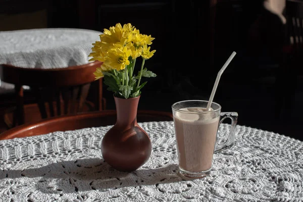 Glass of tasty chocolate milk on wooden table, space for text. Dairy drink