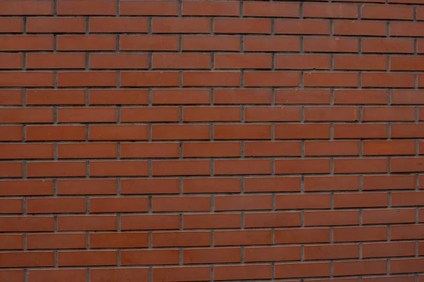 Brick wall background. Červená cihla. Kostkovaná zeď z červených cihel — Stock fotografie