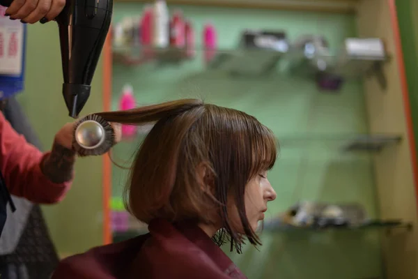 理发师在美容院为一个可爱的小女孩做了一个发型. — 图库照片