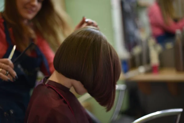 理发师在美容院为一个可爱的小女孩做了一个发型. — 图库照片