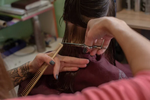 Stylist kapper maakt een kapsel voor een schattig klein meisje in een schoonheidssalon. — Stockfoto