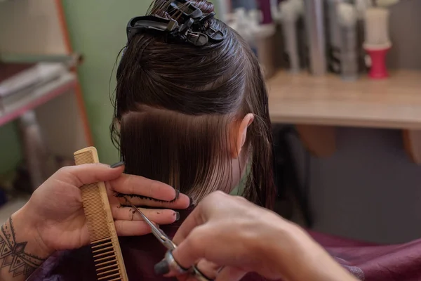 Стиліст перукар робить зачіску для милої маленької дівчинки в салоні краси . — стокове фото