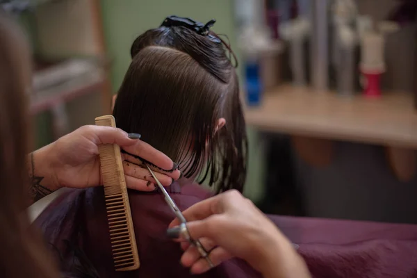 Stylista fryzjer sprawia, że fryzura dla cute little girl w salonie piękności. — Zdjęcie stockowe