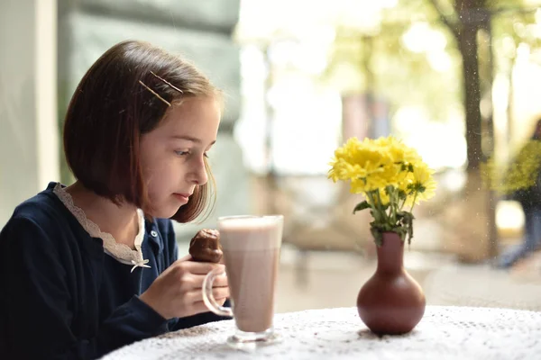 Маленькая девочка пьет горячий шоколад в кафе — стоковое фото