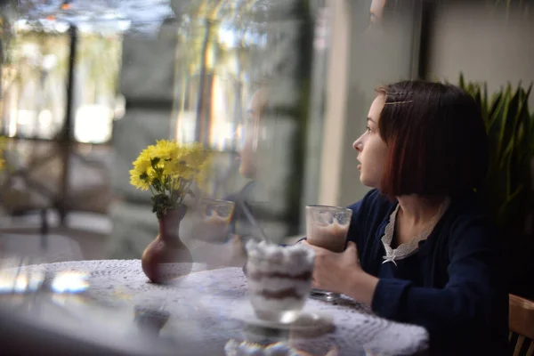 Kleines Mädchen trinkt heiße Schokolade in einem Café — Stockfoto