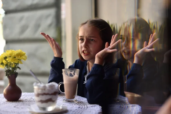 Маленькая девочка пьет горячий шоколад в кафе — стоковое фото