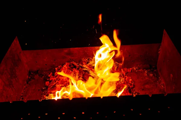 たき火の夜。夕方に杭を調理するためのグリルで薪の点火。夜の炎の光. — ストック写真