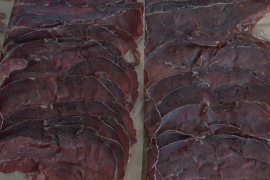 Dilimlenmiş Bresaola. Bresaola - İtalyan usulü kurutulmuş et.