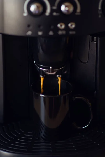 Вкусная чашка эспрессо, которую наливают из домашней кофеварки — стоковое фото