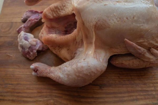 Frango inteiro cru orgânico em fundo rústico de madeira — Fotografia de Stock