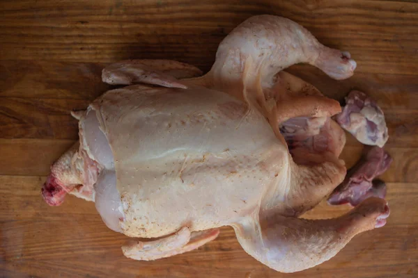 Pollo intero crudo biologico su sfondo rustico in legno — Foto Stock