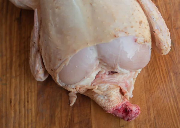 Pollo intero crudo biologico su sfondo rustico in legno — Foto Stock