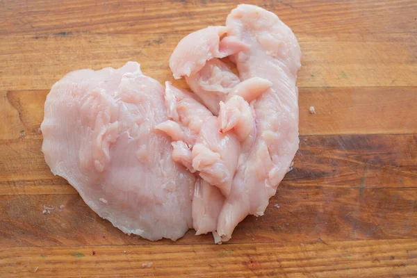Carne fresca de pollo sobre tabla de madera sobre mesa. Enfoque selectivo. Estilo rústico . — Foto de Stock