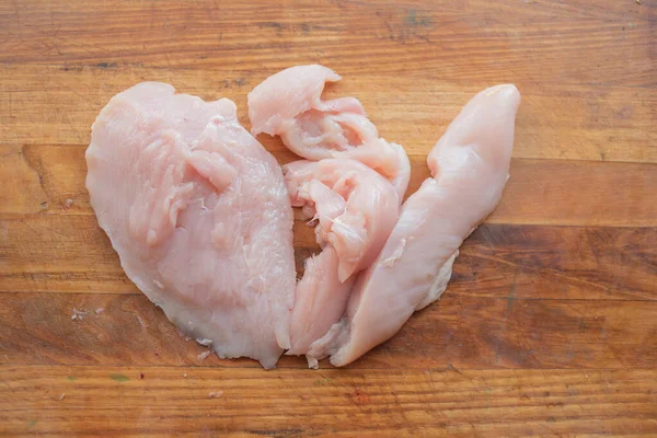 Carne fresca de pollo sobre tabla de madera sobre mesa. Enfoque selectivo. Estilo rústico . — Foto de Stock