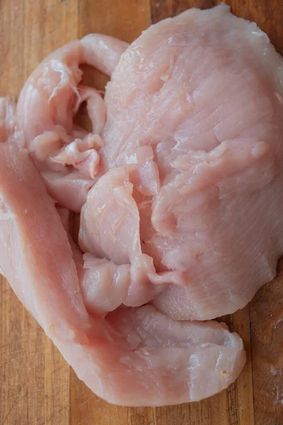 Fresh chicken meat on wooden board on table . Selective focus. Rustic style.