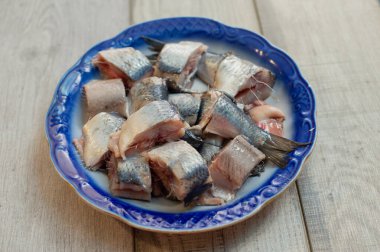 Tuz, biber, otlar ve beyaz arka plan üzerinde beyaz seramik plaka üzerinde limon ile ringa balığı