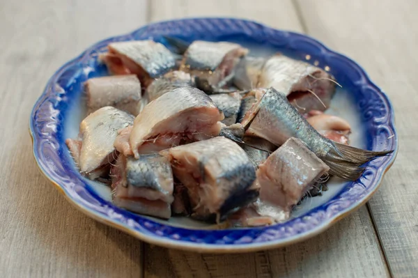 Aringa con sale, pepe, erbe aromatiche e limone su piatto di ceramica bianca su fondo bianco — Foto Stock