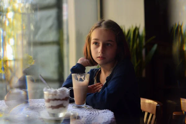 Маленькая девочка пьет горячий шоколад в кафе. школьница пьет какао в кафе . — стоковое фото