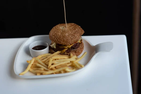 Burger and french fries on a table in a cafe