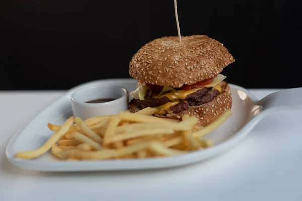 Burger and french fries on a table in a cafe