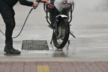 Motosikletli Oto Yıkama Motorsikletli Büyük Bisiklet Temizliği köpük enjeksiyonuyla daha temiz olur. Bir motorcunun motosikletini oto yıkamada yıkadığı bir dizi fotoğraf. Motosikletin siyah-beyaz-kırmızı rengi. Temiz araç