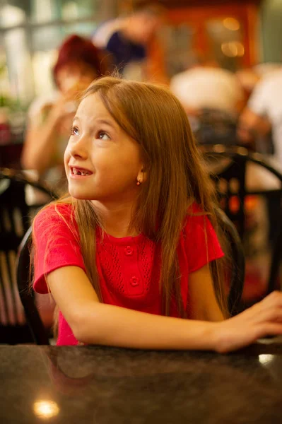 Een Schattig Klein Meisje Een Rood Shirt Aan Een Tafel — Stockfoto